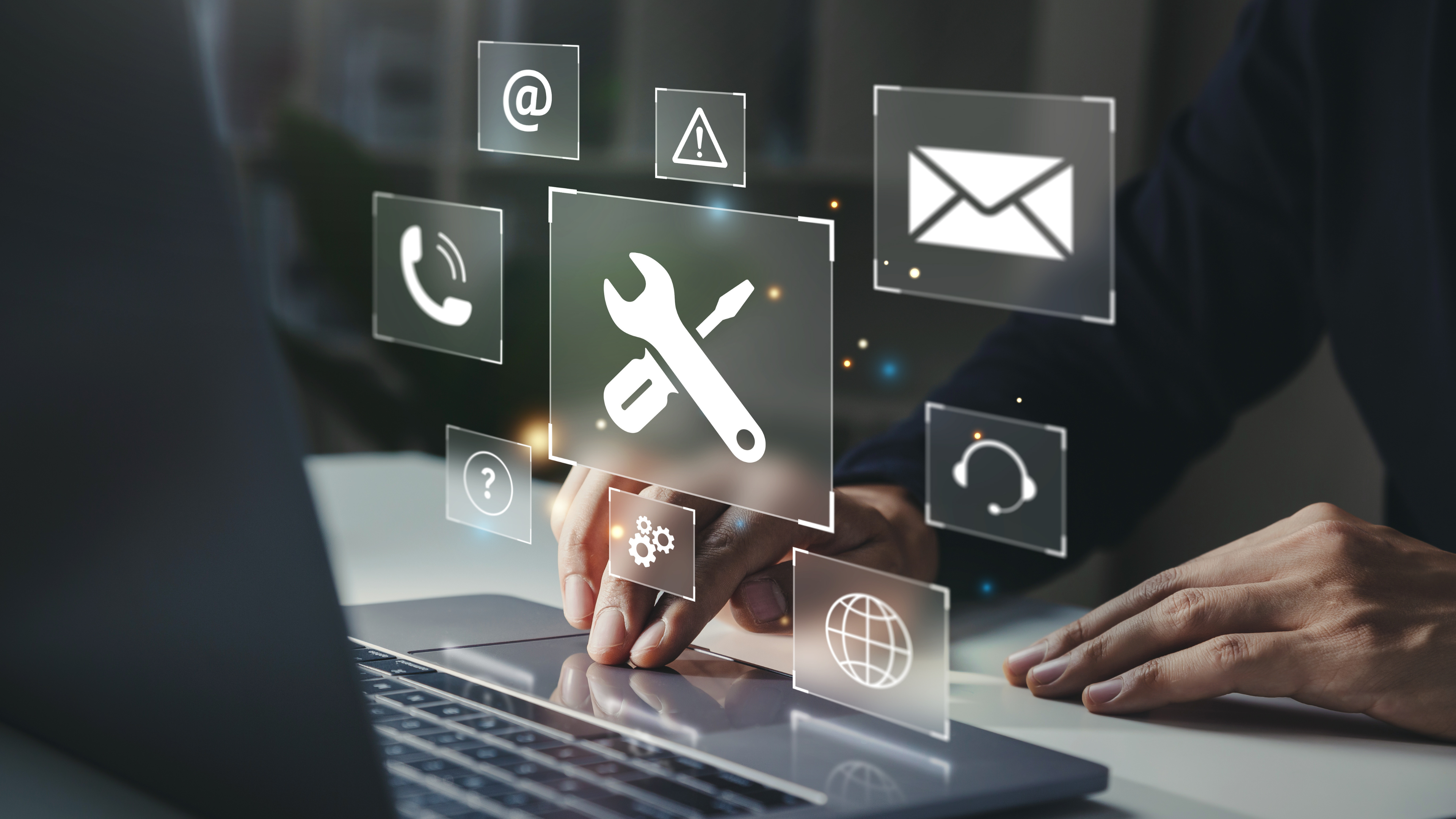 person at laptop with icons hovering from laptop screen